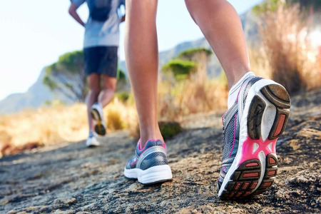 Woman in sneakers walking around a trail 